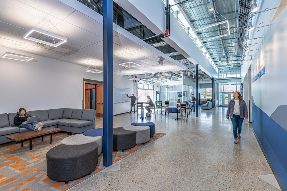 A picture of Treasure Valley Community College with a woman walking past collaborative learning spaces